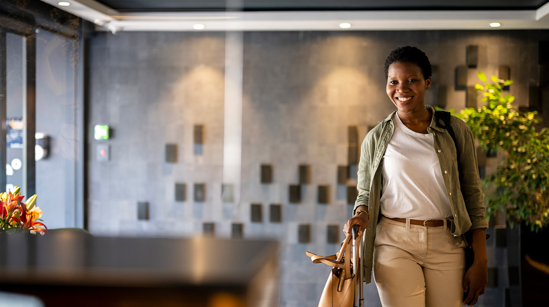 Employee with suitcase entering a furnished apartment